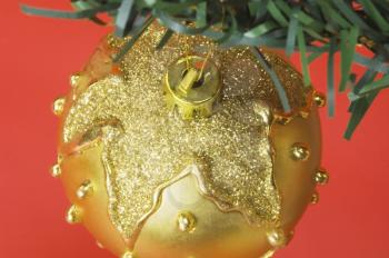 Golden bauble hanging on a Christmas tree