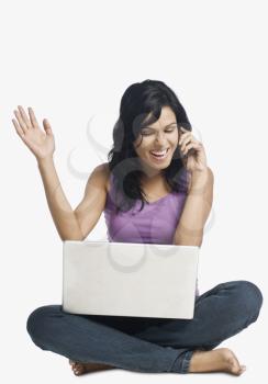 Woman with a laptop and talking on a mobile phone