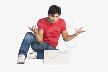 Man gesturing in front of a laptop