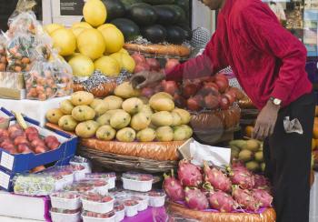 Man choosing fruits at a market stall, New Delhi, India