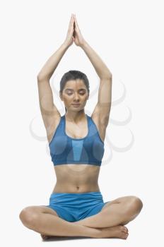Young woman practicing yoga against white background