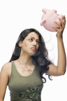 Young woman worried with a piggy bank