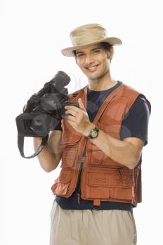 Portrait of a young male videographer holding a videography camera