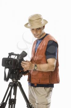 Young male videographer adjusting a videography camera on a tripod