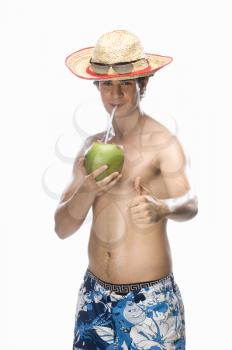 Man drinking coconut milk and showing thumbs up