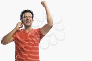 Man talking on a mobile phone and clenching fist