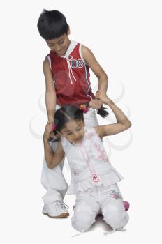 Boy pulling hair of his sister