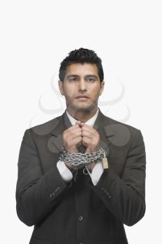 Portrait of a businessman locked with chains