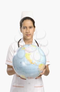Female nurse holding a globe and smiling