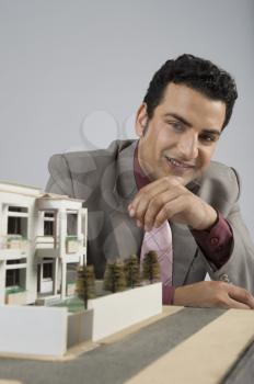 Businessman with a model home in an office