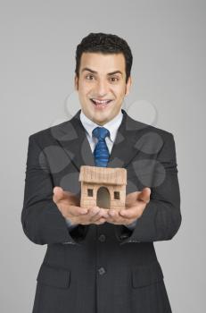 Businessman holding a model home