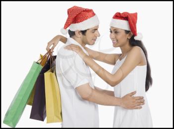 Couple wearing Santa hats and romancing