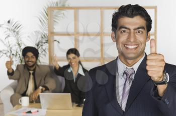 Business executives showing thumbs up sign