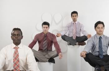 Four businessmen practicing yoga