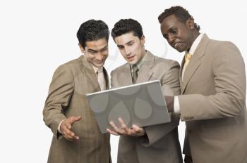 Three businessmen standing with a laptop