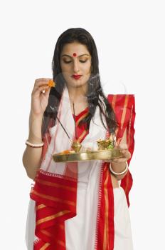 Woman in a Bengali sari holding pooja thali