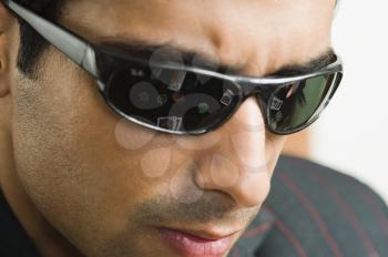 Reflections of playing cards and gambling chips in the goggles worn by a man in casino