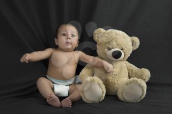 Baby boy sitting with a teddy bear