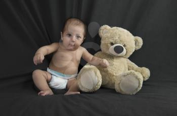 Baby boy sitting with a teddy bear