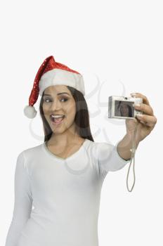 Woman taking a picture of herself with a digital camera