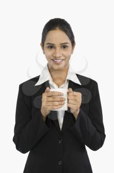 Businesswoman holding a cup of tea and smiling