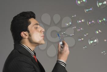 Businessman blowing bubbles