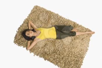 High angle view of a woman lying on a rug