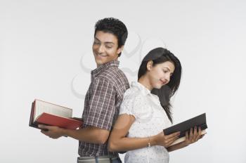College students standing back to back and reading books