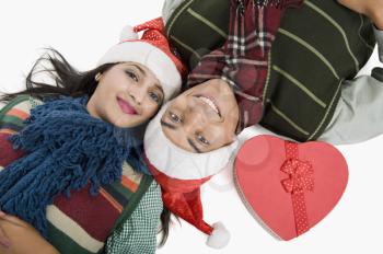 Close-up of a couple lying on a floor with Christmas present