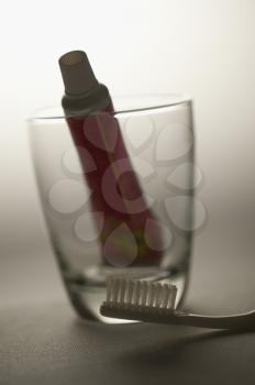 Close-up of a toothbrush and a toothpaste in a glass
