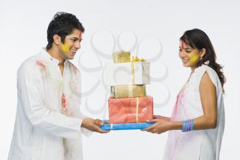 Couple holding Holi gifts