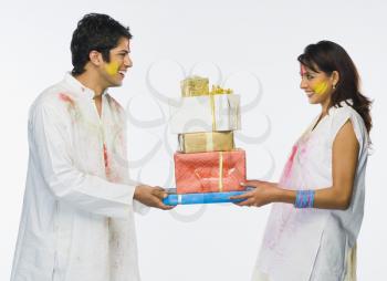 Couple holding Holi gifts