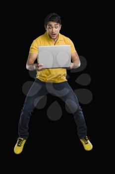 Man working on a laptop and looking surprised