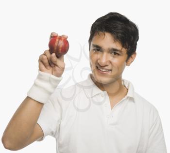 Cricket player showing a cricket ball
