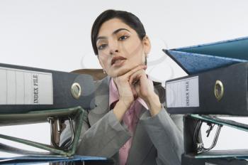 Stack of ring binders in front of a businesswoman