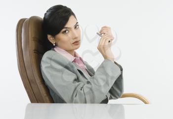 Businesswoman filing her nails in an office