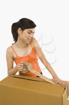 Woman packing cardboard by packing tape