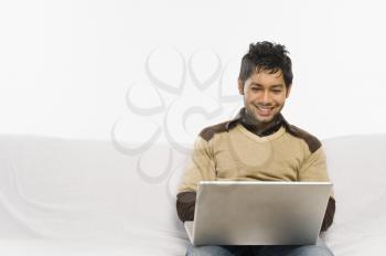 Man working on a laptop and smiling