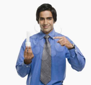 Portrait of a businessman pointing at a light bulb