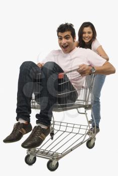 Woman pushing a man sitting in shopping cart