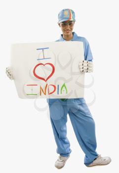 Woman in cricket uniform holding a placard with text I Love India written on it