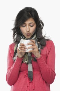 Woman blowing into a coffee cup