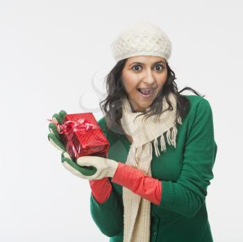 Woman holding a gift box and looking surprised