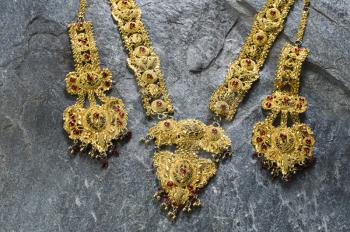 Close-up of a gold necklace and a pair of earrings