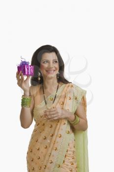 Woman holding Diwali gift and smiling