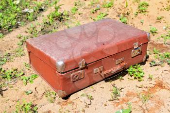 old valise on yellow sand