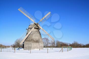 aging wind mill on winter field