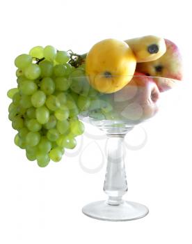 Fruit: grapes, apples, banana, in a glass vase on a white background.                     