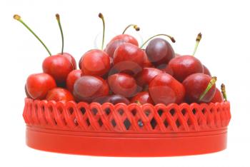 Sweet cherry fruits in a red plate on a white background.                   