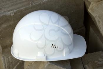 Protective building white helmet, on a against bricks.                  